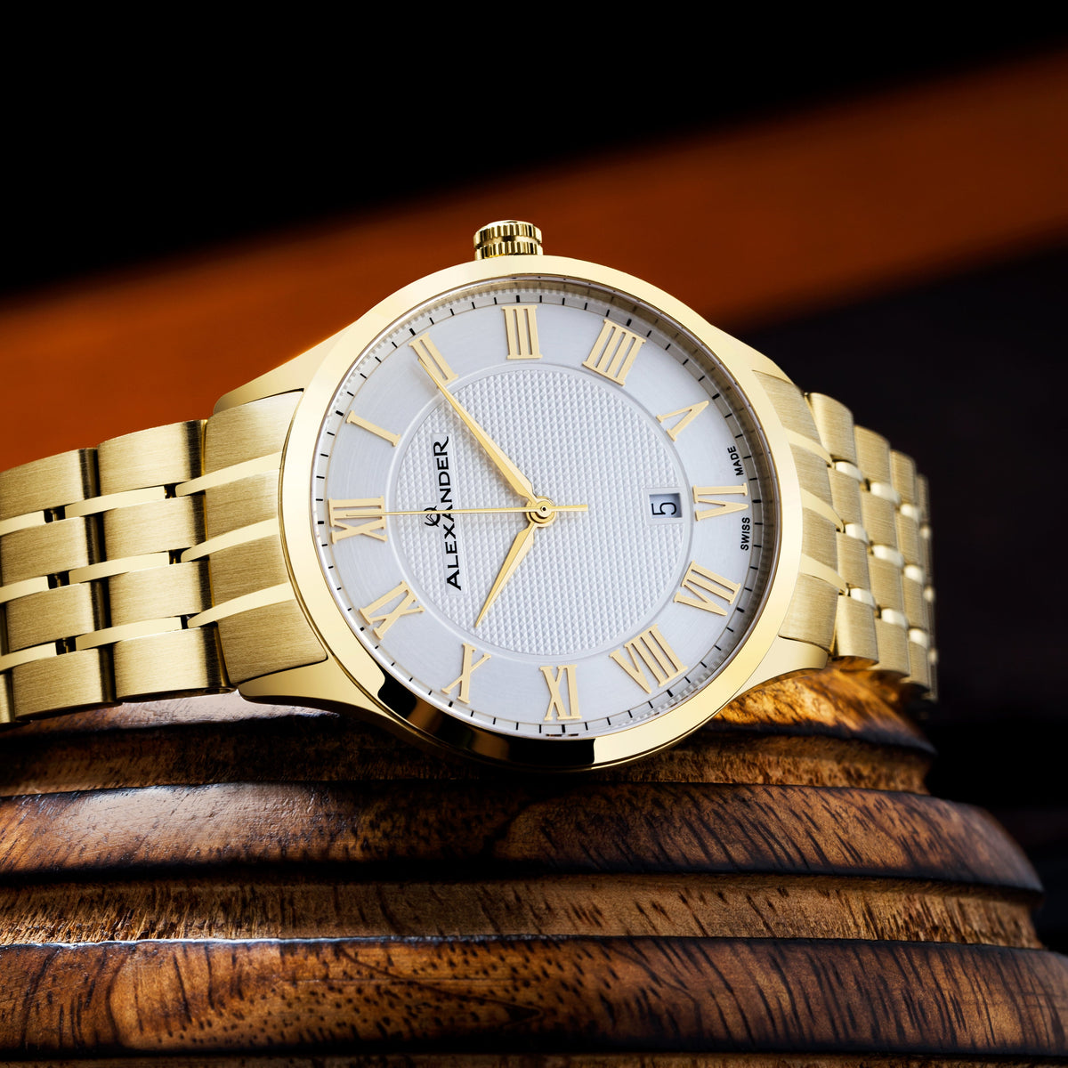 Gold wristwatch with a white face on a wooden surface