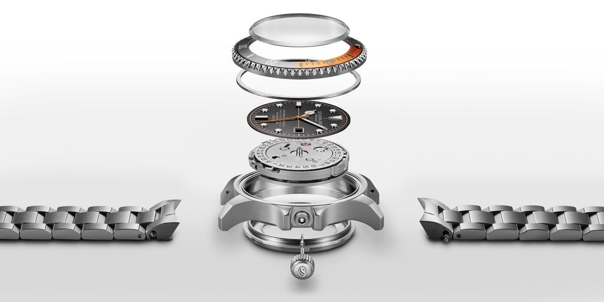 Watch components including a metal bracelet on a white background