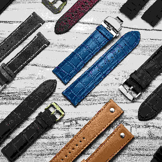 Collection of various watch straps on a textured surface